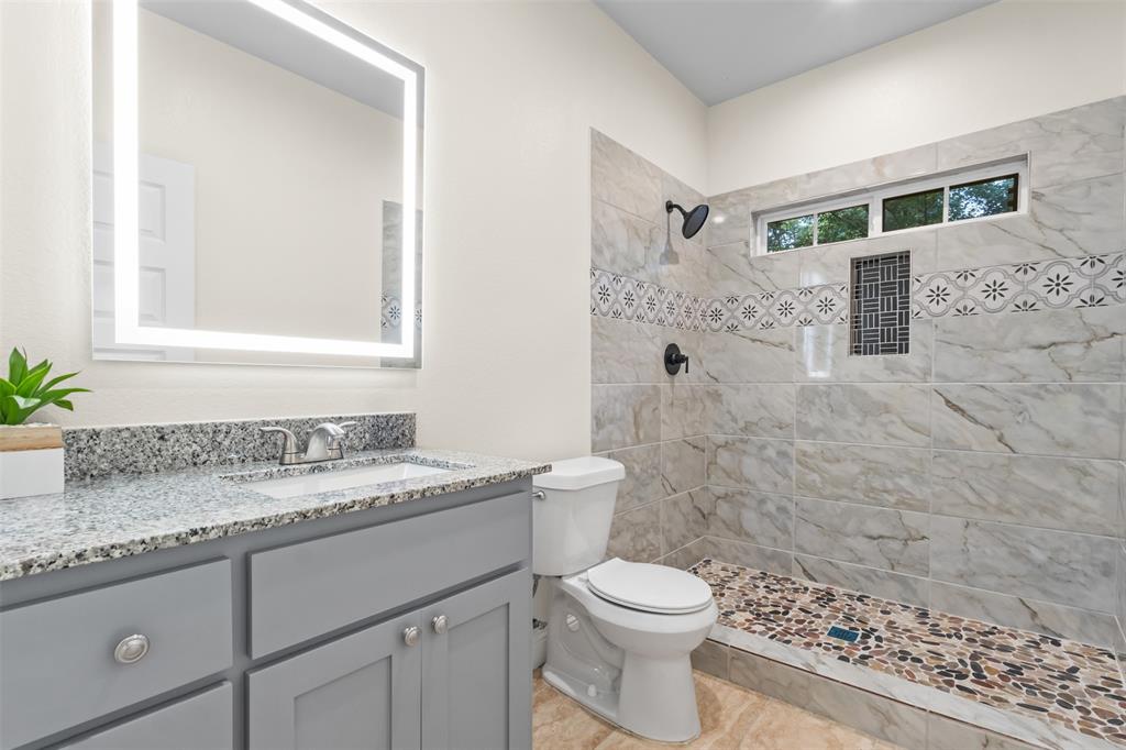 117 Pawnee Trail Mabank, TX 75156 - Photo 6 of 40 a bathroom with a granite countertop sink a toilet a mirror and shower