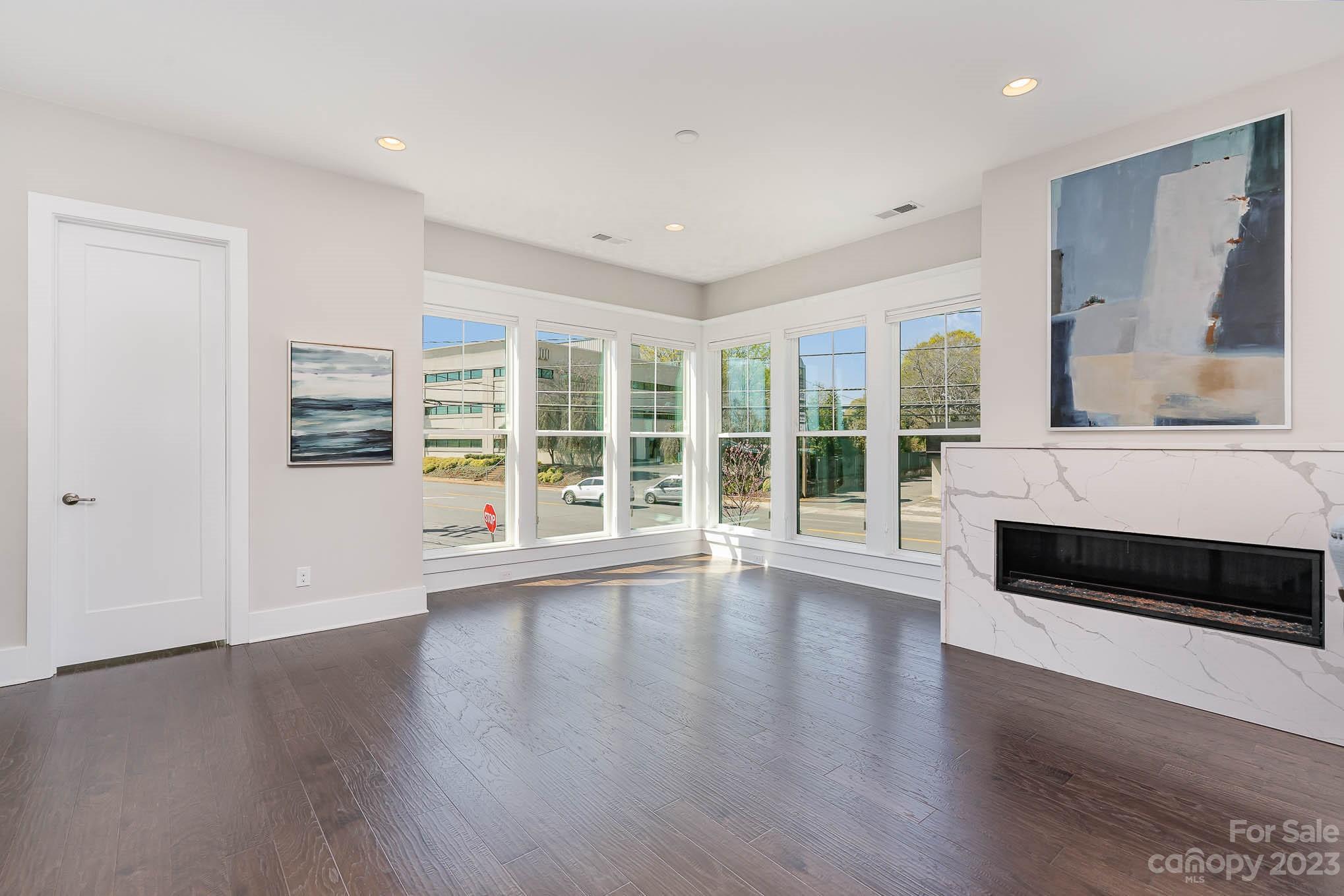 1103 Reece Road Charlotte, NC 28209 - Photo 3 of 32 a view of an empty room with wooden floor and a window