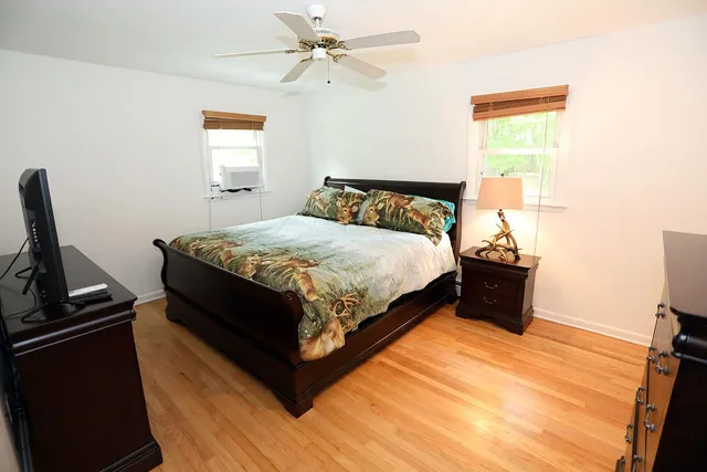 a bedroom with a bed and wooden floor