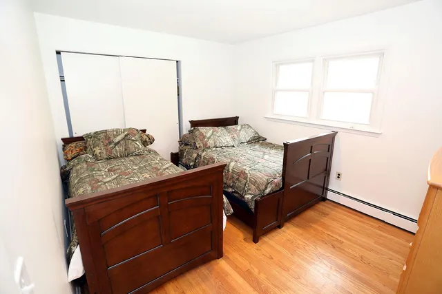 a bed sitting in a bedroom next to a window with dresser