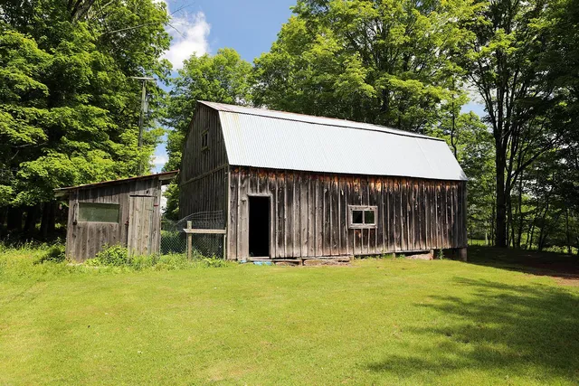 a front view of house with yard and trees in the background