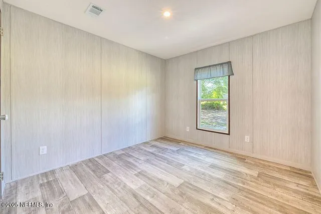 an empty room with windows and closet