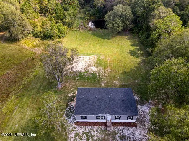an aerial view of a house with a yard swimming pool and outdoor seating
