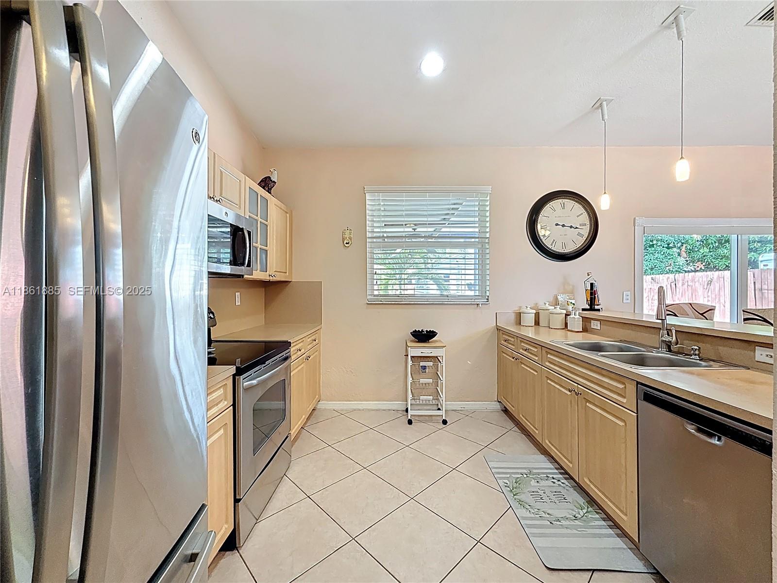 30030 Southwest 154th Avenue Homestead, FL 33033 - Photo 24 of 70 a kitchen with stainless steel appliances a stove a sink and a refrigerator