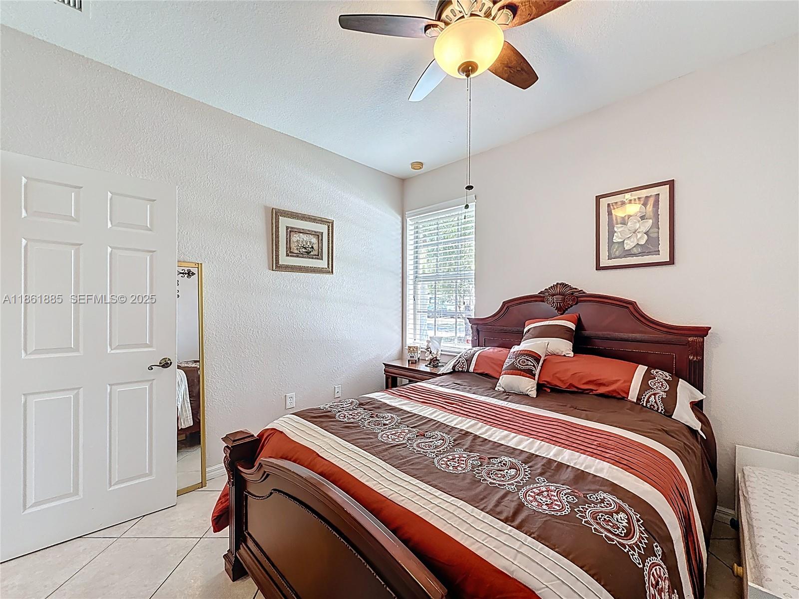 30030 Southwest 154th Avenue Homestead, FL 33033 - Photo 31 of 70 a bedroom with a bed and a chandelier