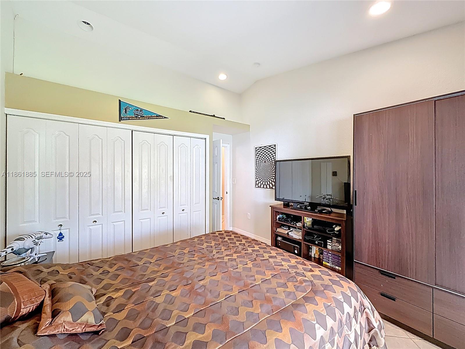 30030 Southwest 154th Avenue Homestead, FL 33033 - Photo 34 of 70 a bedroom with a bed and a flat tv screen on dresser