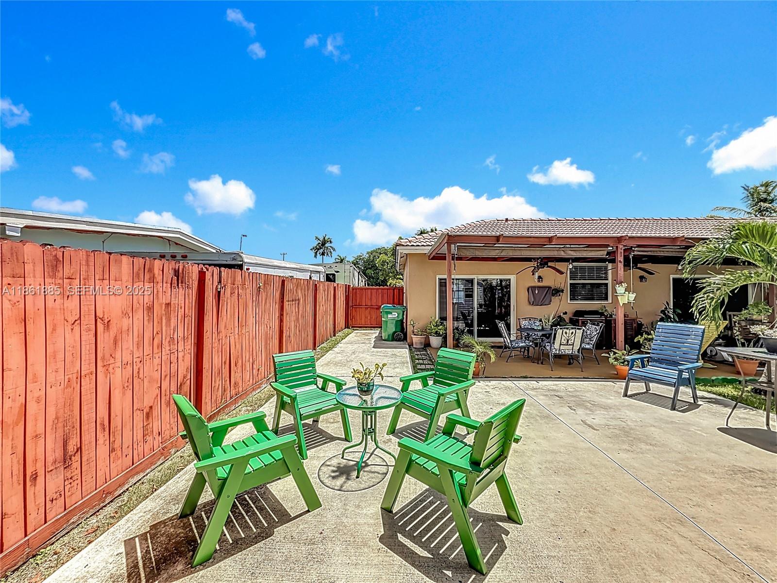 30030 Southwest 154th Avenue Homestead, FL 33033 - Photo 56 of 70 a view of a patio with table and chairs potted plants and a large tree