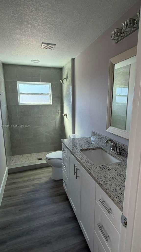 6805 Heavitree Drive Sebring, FL 33876 - Photo 48 of 61 a bathroom with a granite countertop sink a toilet a mirror and shower