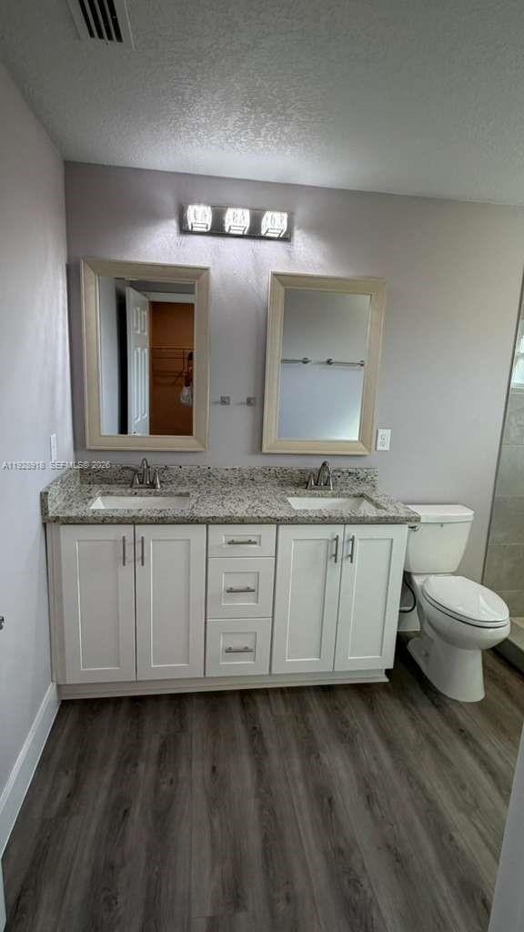 6805 Heavitree Drive Sebring, FL 33876 - Photo 49 of 61 a bathroom with a granite countertop toilet sink and mirror