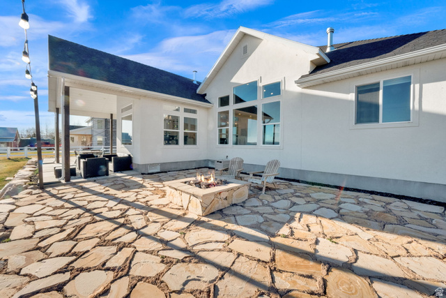 352 East Boulderville Road Oakley, UT 84055 - Photo 42 of 62 Back of property with a patio area, a fire pit, roof with shingles, and stucco siding