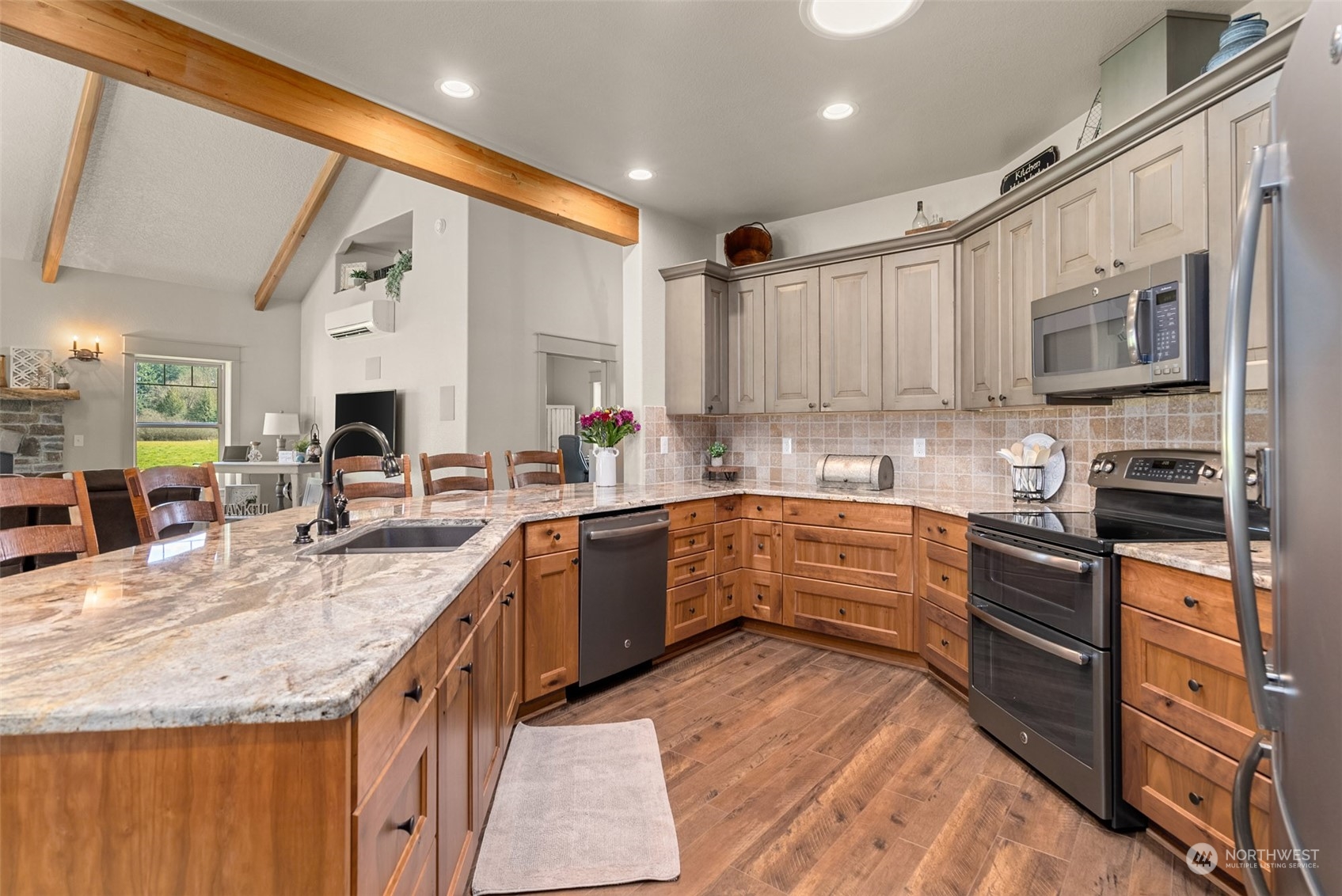 9336 James Road Southwest Rochester, WA 98579 - Photo 14 of 40 a kitchen with stainless steel appliances granite countertop a stove top oven a sink dishwasher a dining table and chairs with wooden floor