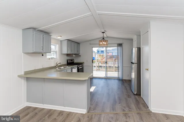 a kitchen with white cabinets and a stove with wooden floors