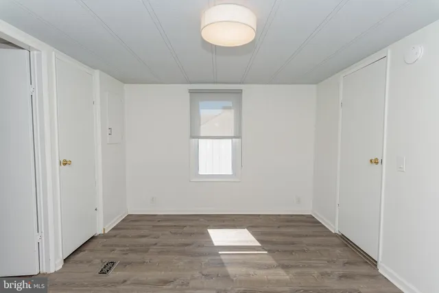 a view of a room with wooden floor and a window