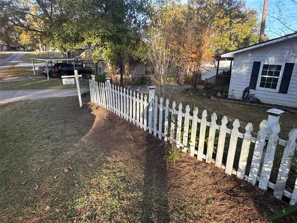 a view of a house with backyard and trees