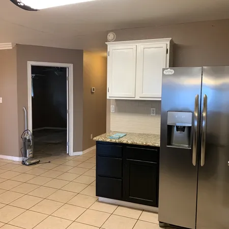 a kitchen with a refrigerator and cabinets