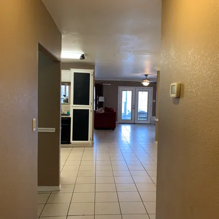 a view of a hallway with wooden floor and windows
