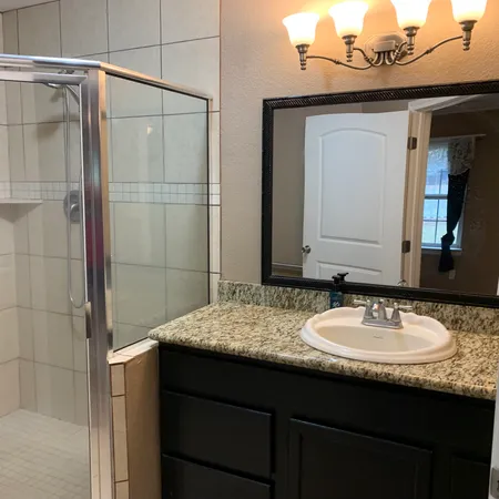 a bathroom with a granite countertop sink and a mirror