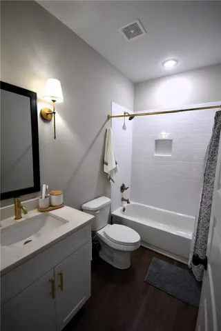 a bathroom with a double vanity sink toilet mirror and shower