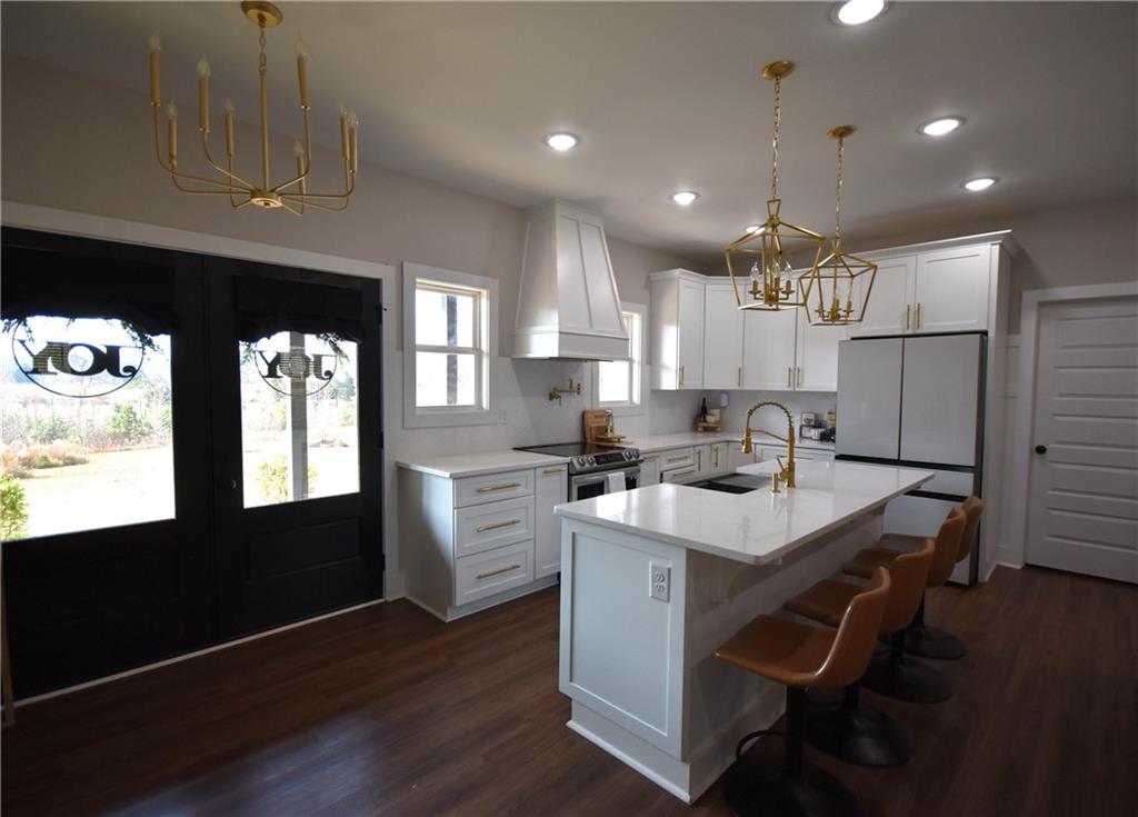 533 Lively Road Waco, GA 30182 - Photo 22 of 41 a kitchen with stainless steel appliances kitchen island granite countertop a table chairs and a refrigerator