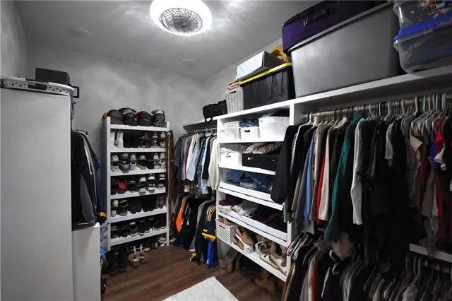 a view of walk in closet with clothes and shoes