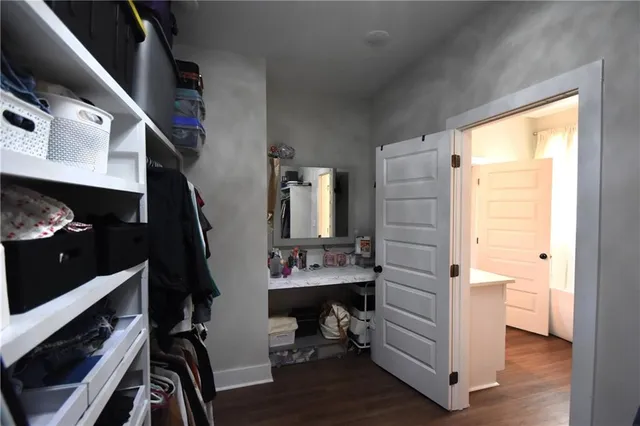 a view of walk in closet with clothes and shoes