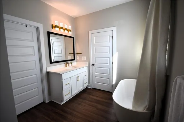 a bathroom with a toilet a sink a mirror and a window