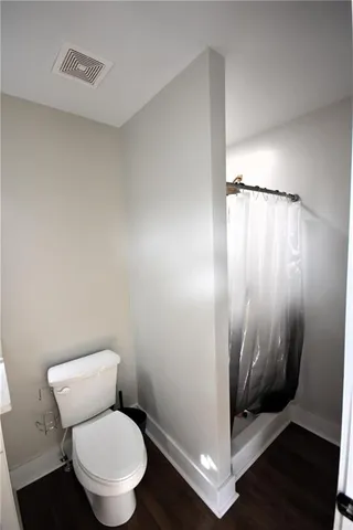 a bathroom with a toilet and a shower