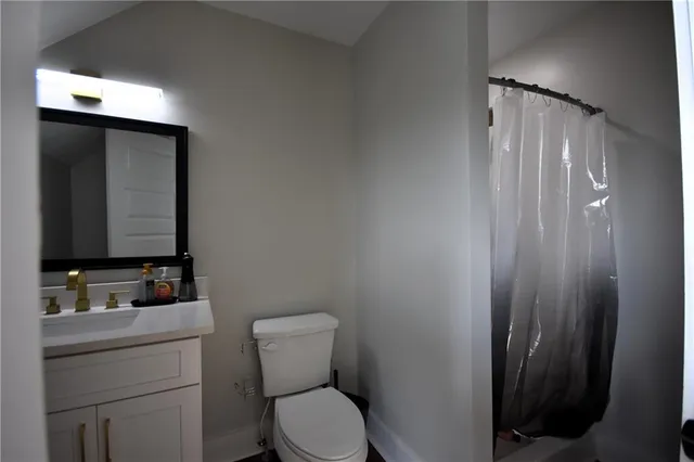 a bathroom with a toilet sink vanity and mirror