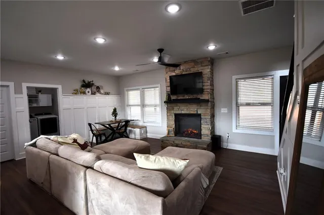 a living room with furniture a fireplace and a flat screen tv