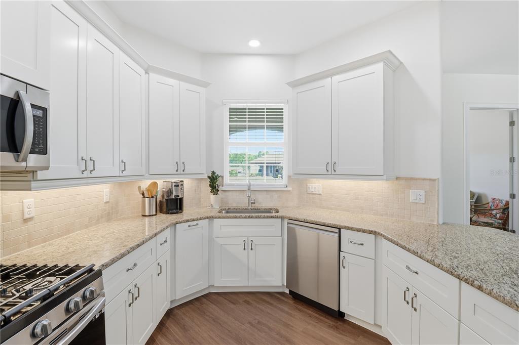 5470 West Hunter Run Lane Homosassa, FL 34446 - Photo 11 of 46 a kitchen with granite countertop white cabinets and white appliances