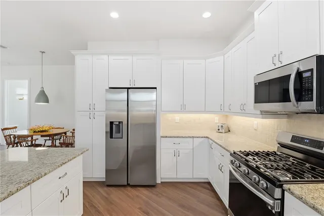 a kitchen with stainless steel appliances granite countertop a refrigerator and a sink