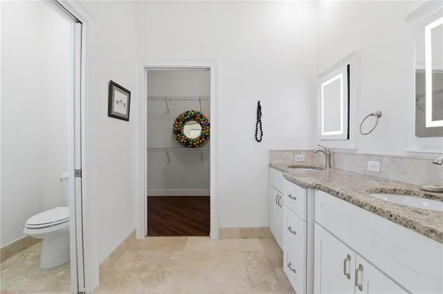 a spacious bathroom with a granite countertop sink and a mirror