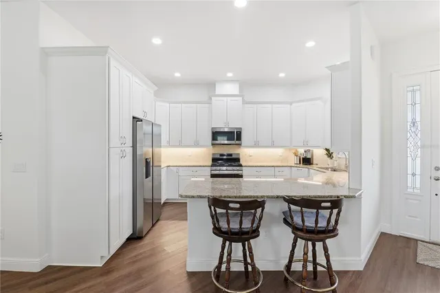 a kitchen with kitchen island wooden cabinets and refrigerator