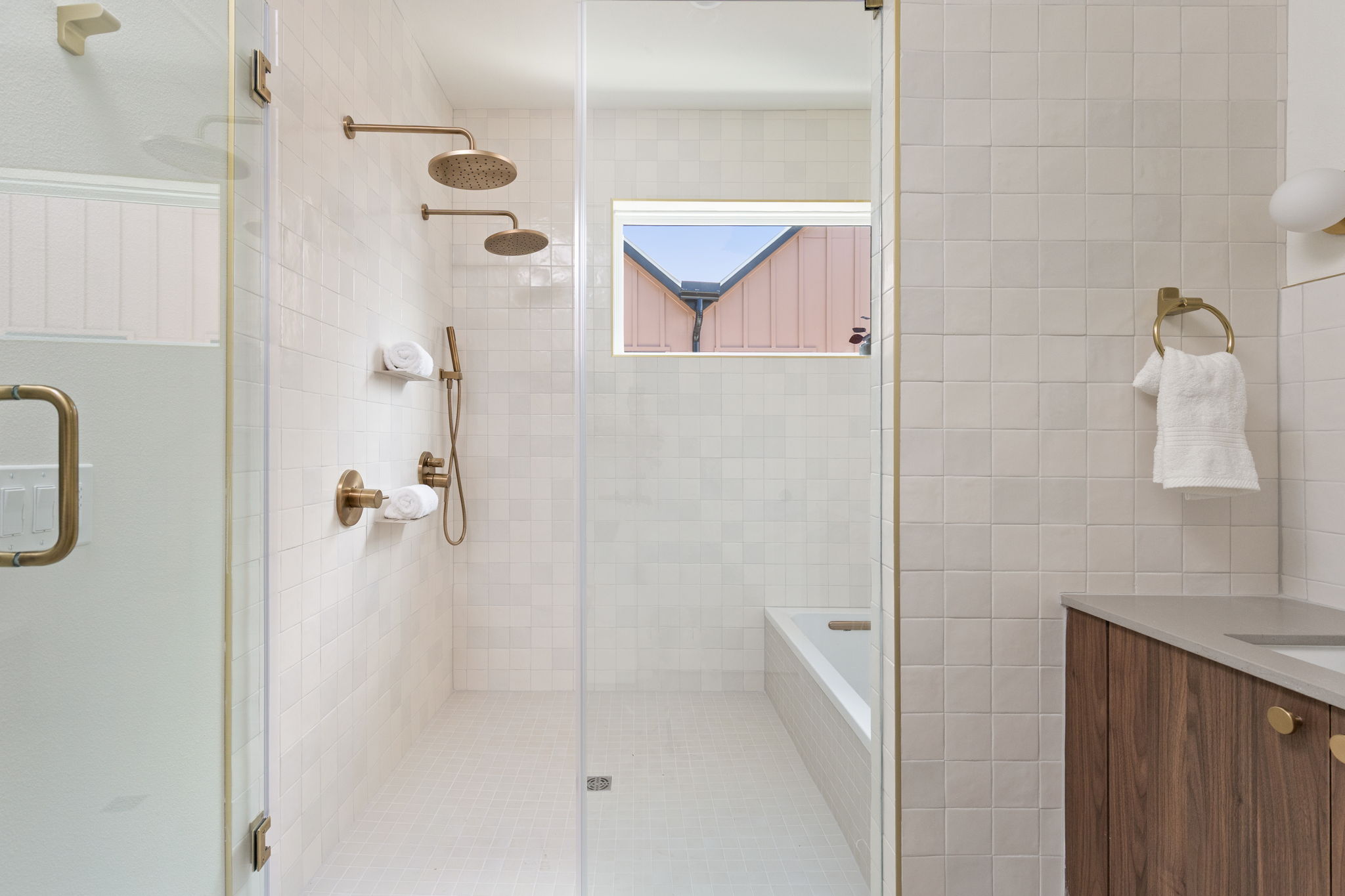 732 Springdale Road, Unit A Austin, TX 78702 - Photo 14 of 18 Modern bathroom featuring dual showerheads, sleek glass enclosure, and a built-in tub for ultimate relaxation.