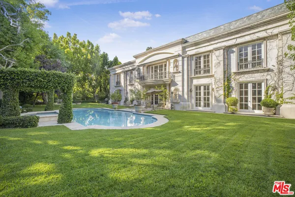 a view of a house with a swimming pool and a yard