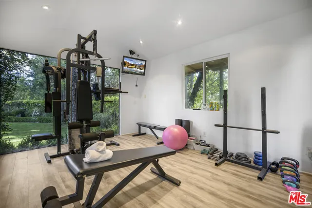 a spacious bedroom with a bed and a flat screen tv