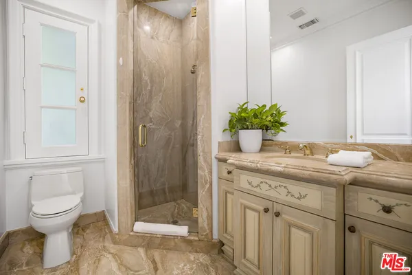 a kitchen with granite countertop chairs and white cabinets