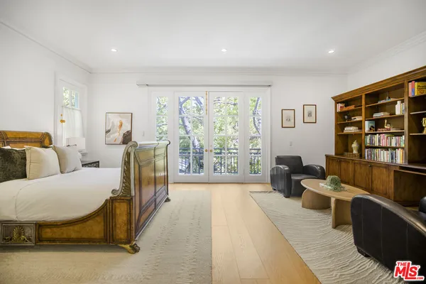 a bedroom with a bed and a large window