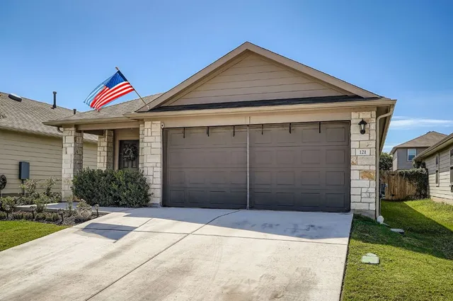 a front view of a house with a yard and garage