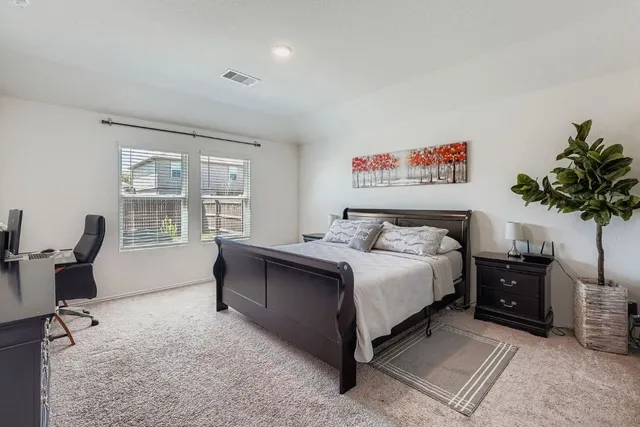 a spacious bedroom with a bed and a desk