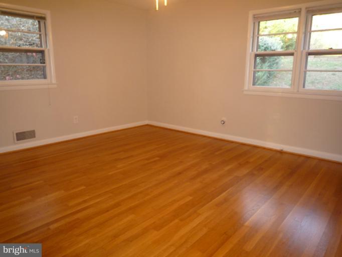 7207 Fort Hunt Road Alexandria, VA 22307 - Photo 6 of 15 an empty room with wooden floor and windows