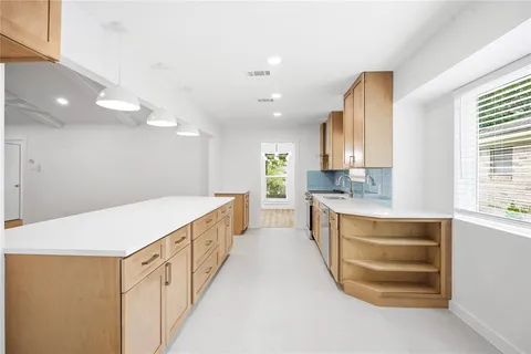 a large kitchen with kitchen island a sink stainless steel appliances and cabinets