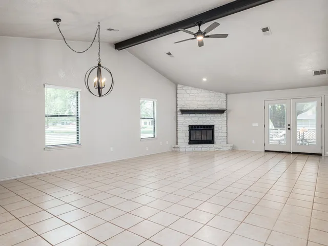 an empty room with windows and fan