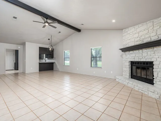 a view of an empty room and a kitchen