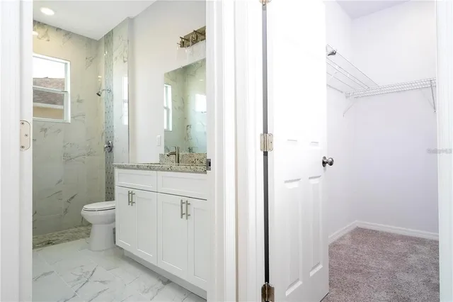 a bathroom with a granite countertop sink toilet and shower