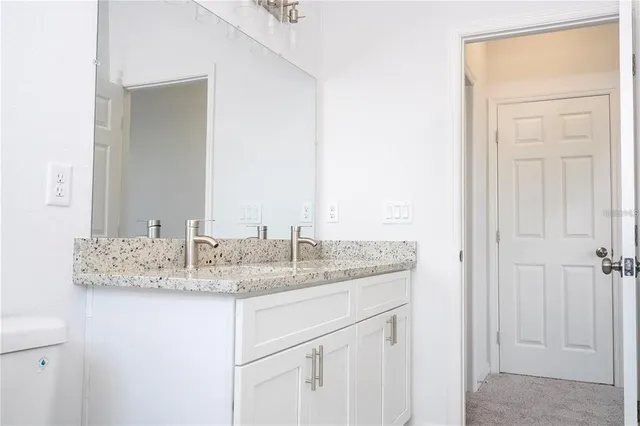 a bathroom with a granite countertop sink and a mirror