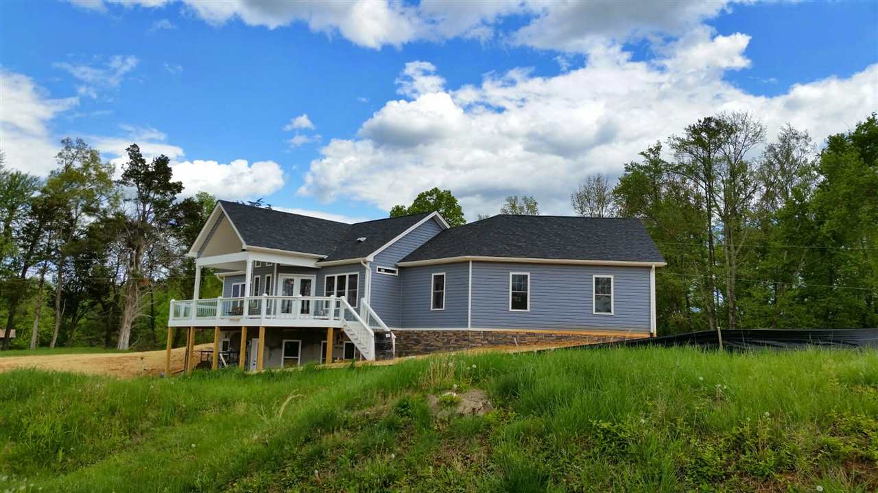 a view of a house with a big yard plants and large trees
