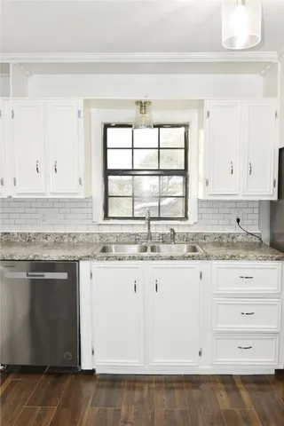 a kitchen with granite countertop white cabinets and white appliances