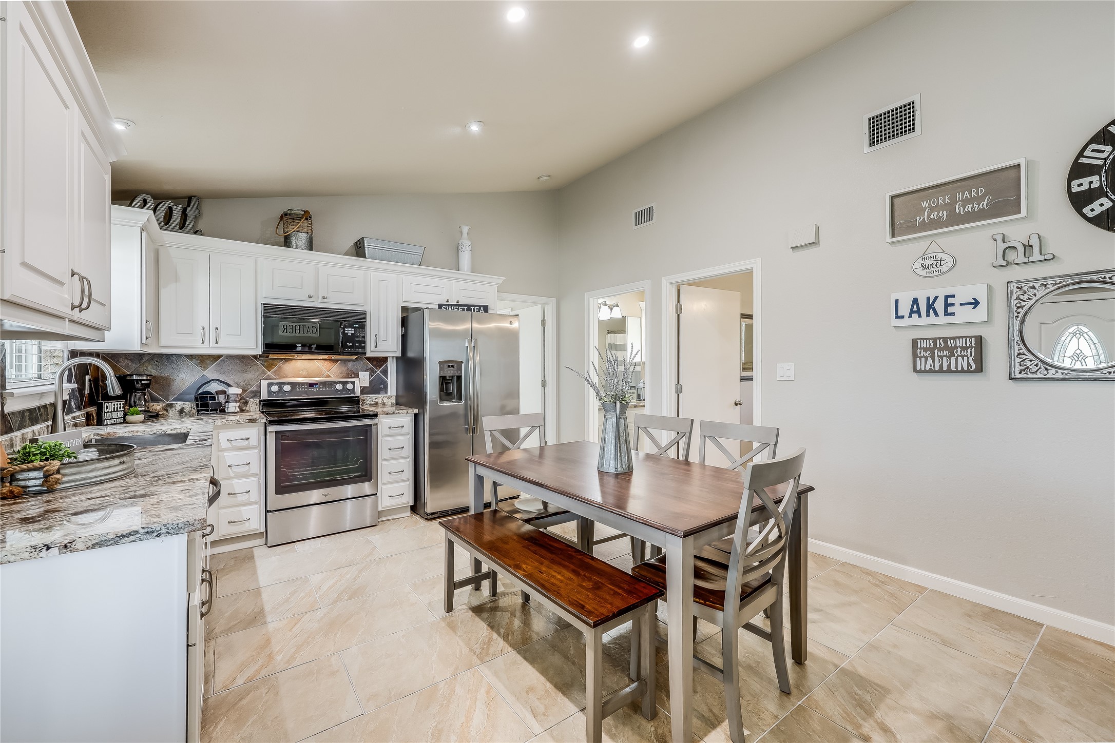 426 Summit Ridge Drive North Point Venture, TX 78645 - Photo 11 of 28 a room with stainless steel appliances kitchen island granite countertop a dining table chairs and a refrigerator