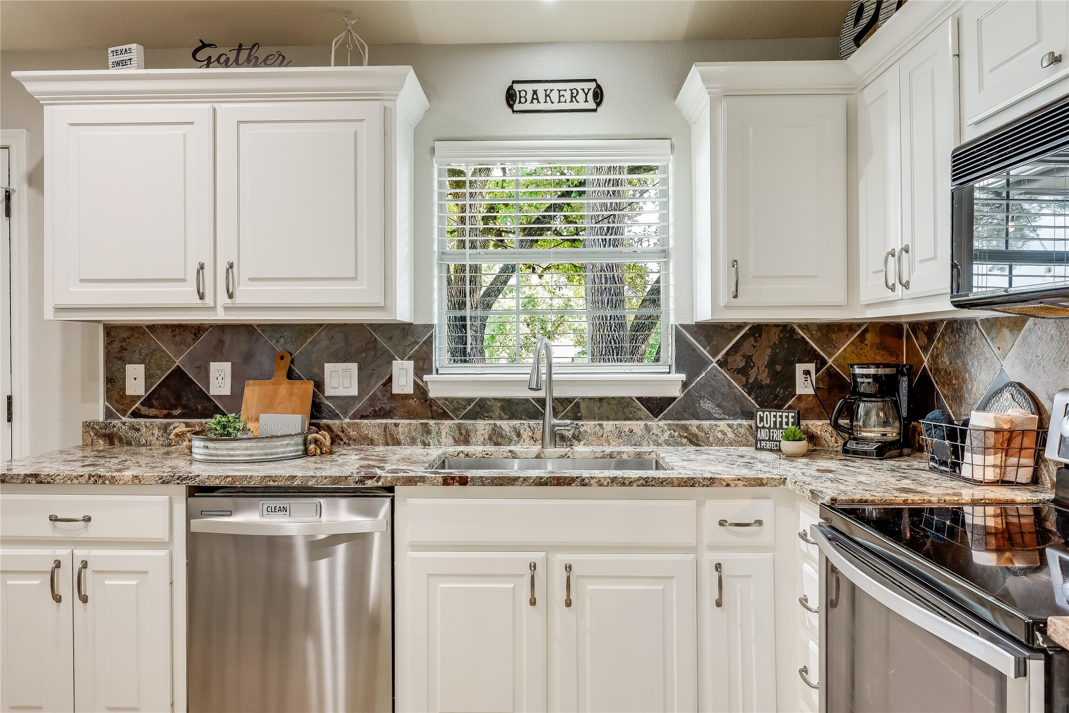 426 Summit Ridge Drive North Point Venture, TX 78645 - Photo 13 of 28 a kitchen with stainless steel appliances granite countertop a sink window and cabinets